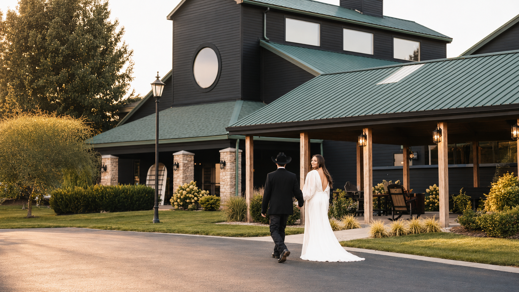 Bride and groom walking toward The Show Barn cabins at golden hour