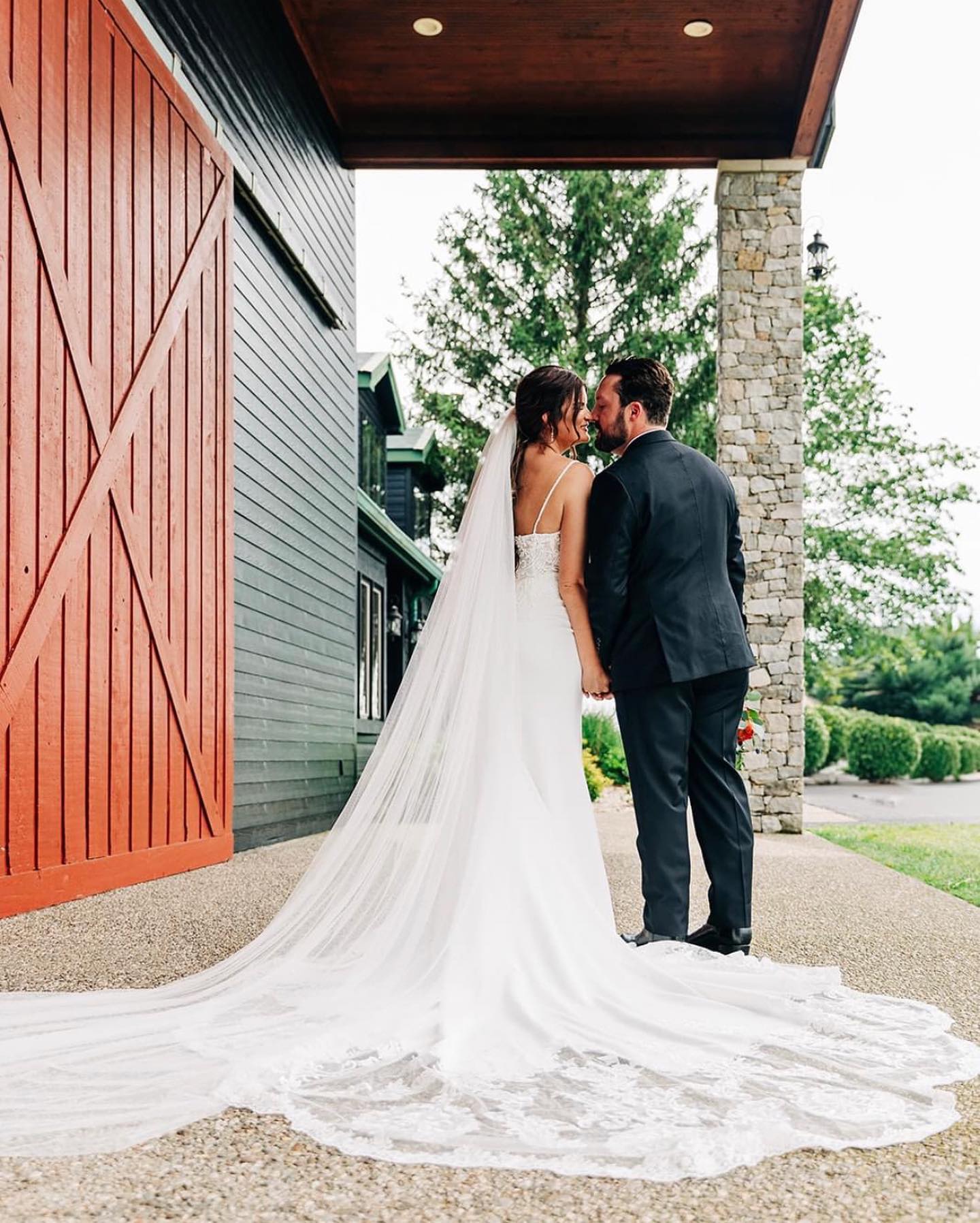 Bride and groom embracing beside the barn doors at The Show Barn